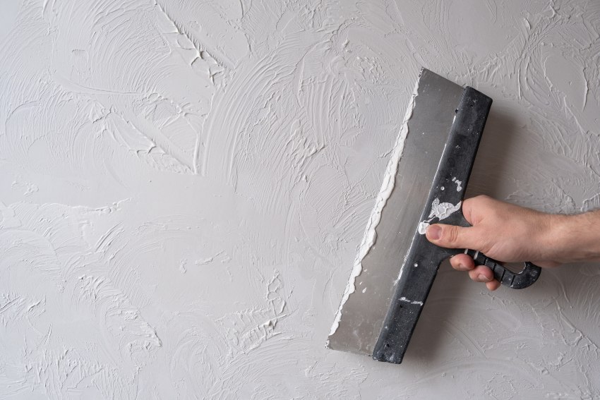 A person utilizes a tool to apply synthetic/acrylic stucco in San Jose, CA